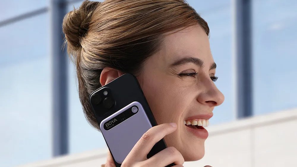 Una donna al telefono con il Notra agganciato al retro dello smartphone, immagine ufficiale BOYA